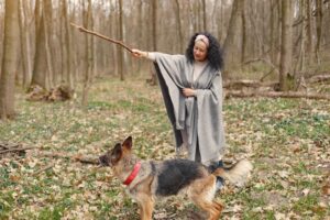 Woman walking a dog on a woodland path